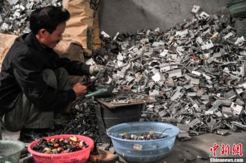 资料图：2013年4月8日，广东汕头贵屿镇上一名工人正在分拣电子元件。中新社发 洪坚鹏 摄
